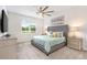 Comfortable bedroom featuring a large window offering serene outdoor views and a decorative ceiling fan at 9095 Rally Spring Loop, Wesley Chapel, FL 33545