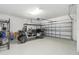 Spacious garage with a golf cart and epoxy flooring, offering ample room for vehicles and storage at 9095 Rally Spring Loop, Wesley Chapel, FL 33545