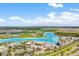 Aerial view of a vibrant community lagoon featuring sandy beaches, clear turquoise waters, and recreational activities at 9095 Rally Spring Loop, Wesley Chapel, FL 33545