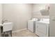 Functional laundry room with a utility sink, washer, dryer, and wire shelving for storage solutions at 9095 Rally Spring Loop, Wesley Chapel, FL 33545