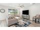 Cozy living room with plush seating, a large window offering a tranquil view, and contemporary decor creating a relaxing atmosphere at 9095 Rally Spring Loop, Wesley Chapel, FL 33545