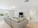 Bright living room with neutral tones, a comfortable gray sofa, and an entertainment center with a modern television at 9095 Rally Spring Loop, Wesley Chapel, FL 33545