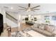 Inviting living space with stairs leading to an upper level, an open kitchen view, and a comfortable sofa for relaxing or entertaining at 9095 Rally Spring Loop, Wesley Chapel, FL 33545