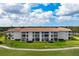 Beautiful condo building featuring a red tile roof, screened balconies, and well-maintained landscaping at 9630 Club South Cir # 6201, Sarasota, FL 34238