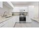 Well-lit kitchen features white cabinets, granite countertops, stainless steel appliances and neutral flooring at 9630 Club South Cir # 6201, Sarasota, FL 34238