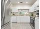 The bright kitchen features granite countertops, stainless steel appliances, white cabinetry and tile floors at 9630 Club South Cir # 6201, Sarasota, FL 34238