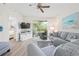 Bright living room with modern decor, light wood floors, and balcony access offering a serene view from the sofa at 9630 Club South Cir # 6201, Sarasota, FL 34238