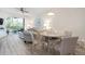 Bright living room with a dining area, wood floors, comfortable seating, and a screened balcony at 9630 Club South Cir # 6201, Sarasota, FL 34238
