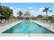 Serene community pool surrounded by palm trees, lounge chairs, and a screened cabana at 9630 Club South Cir # 6201, Sarasota, FL 34238