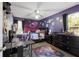 Purple themed bedroom with bed, desk, dresser, ceiling fan, hardwood floors, window providing natural light and outer space decorations at 10615 Boyette Creek Blvd, Riverview, FL 33569