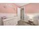 Bright pink bedroom with white wainscoting and view into ensuite bathroom at 11869 Richmond Trl, Parrish, FL 34219
