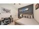 Bright bedroom with a wooden bed frame, black accent wall, and a ceiling fan at 11869 Richmond Trl, Parrish, FL 34219