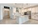Bright kitchen featuring an island, stainless steel appliances, white cabinets, and stylish pendant lighting at 11869 Richmond Trl, Parrish, FL 34219