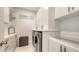 Bright laundry room boasts modern appliances and sleek white cabinetry with gold accents at 11869 Richmond Trl, Parrish, FL 34219