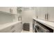 Well-lit laundry room features white cabinets with modern gold hardware, plus modern appliances at 11869 Richmond Trl, Parrish, FL 34219
