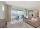 Neutral-toned living room with modern furnishings, a view of the lake, and a sliding glass door to the patio at 11869 Richmond Trl, Parrish, FL 34219