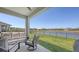 Covered patio with stylish seating, offering beautiful views of the expansive lawn and peaceful lake at 11869 Richmond Trl, Parrish, FL 34219