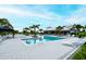 Community pool with palm trees, sun loungers, and nearby clubhouse for residents' enjoyment at 11869 Richmond Trl, Parrish, FL 34219
