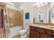 Bathroom features a vanity with granite countertop, a tub with shower, and modern lighting at 12501 Cinqueterre Dr, Venice, FL 34293