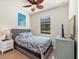 Comfortable bedroom featuring a gray upholstered headboard, a ceiling fan, and a bright window at 12501 Cinqueterre Dr, Venice, FL 34293