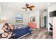 Cozy bedroom with wood-look floors, a ceiling fan, and closet at 12501 Cinqueterre Dr, Venice, FL 34293