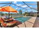 Sparkling pool and spa with screen enclosure and lounging area overlooks a serene lake at 12501 Cinqueterre Dr, Venice, FL 34293