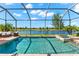 Sparkling pool and spa with screen enclosure overlooks a serene lake and lounging area at 12501 Cinqueterre Dr, Venice, FL 34293