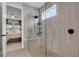 Modern shower with gray tiled walls, glass enclosure, and a built-in bench and open doorway to bedroom at 14514 20Th E St, Parrish, FL 34219
