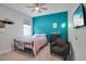 Stylish bedroom featuring a vivid accent wall, ceiling fan and large TV at 14514 20Th E St, Parrish, FL 34219