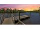 Dock with metal railing provides easy access to the waterfront, framed by a colorful sunset at 14514 20Th E St, Parrish, FL 34219