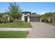 Beautiful single-Gathering home featuring manicured lawn, paved driveway, and elegant exterior lighting at 14514 20Th E St, Parrish, FL 34219