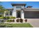 Contemporary home exterior with clean lines, dark accents, manicured landscaping, and a paver driveway at 14514 20Th E St, Parrish, FL 34219