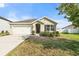 Charming home featuring a neatly landscaped front yard with a black front door and shuttered windows at 14914 Flowing Gold Dr, Bradenton, FL 34212