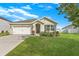 Charming single-story home featuring a well-manicured lawn, a two-car garage, and attractive landscaping at 14914 Flowing Gold Dr, Bradenton, FL 34212