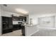 Modern kitchen with dark cabinetry, a breakfast bar, and views of the adjacent living spaces at 14914 Flowing Gold Dr, Bradenton, FL 34212