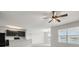 Bright open-concept living room with a ceiling fan and views of the adjacent kitchen and backyard at 14914 Flowing Gold Dr, Bradenton, FL 34212