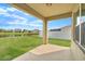 Covered patio with a view of the backyard, pond, and neighboring houses beyond the fence at 14914 Flowing Gold Dr, Bradenton, FL 34212