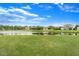 Lush green lawn leading to a pond view, birds and surrounding homes with a bright blue sky at 14914 Flowing Gold Dr, Bradenton, FL 34212