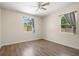 Bright bedroom with hardwood floors, ceiling fan, and two windows for natural light at 1518 Stoeber Ave, Sarasota, FL 34232