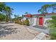 Charming home featuring a vibrant red front door and beautiful landscaping at 1518 Stoeber Ave, Sarasota, FL 34232