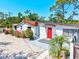 Charming single-story home showcasing colorful flowers, a red front door, and a well-maintained yard at 1518 Stoeber Ave, Sarasota, FL 34232