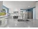 Bright kitchen features stainless steel appliances, gray countertops, light blue accent wall and white cabinets at 1518 Stoeber Ave, Sarasota, FL 34232