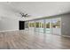 Bright, modern living room with wood-look flooring, ceiling fan, and sliding glass doors to the pool at 1518 Stoeber Ave, Sarasota, FL 34232