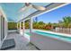 Covered patio with view of in-ground pool, lush landscaping and fenced-in backyard at 1518 Stoeber Ave, Sarasota, FL 34232