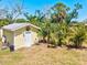 A shed with a white door, a weather vane, and surrounding tropical foliage at 1518 Stoeber Ave, Sarasota, FL 34232
