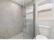 Modern bathroom featuring a glass shower with large light gray tiles and white hexagon tile floor at 1518 Stoeber Ave, Sarasota, FL 34232
