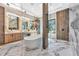 Modern bathroom showcasing a freestanding tub, marble floors, separate shower, and contemporary lighting at 1555 Eastbrook Dr, Sarasota, FL 34231