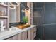 This bathroom boasts wood cabinets, unique black tile, and a white countertop with marble veining at 1555 Eastbrook Dr, Sarasota, FL 34231
