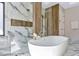 This bathroom features a modern soaking tub with a glass shower, marble accents, and plenty of natural light at 1555 Eastbrook Dr, Sarasota, FL 34231