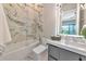 Bathroom featuring a tub and shower combination with marble surround and a contemporary vanity at 1555 Eastbrook Dr, Sarasota, FL 34231